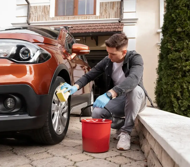 Lavage auto à domicile Le Vibal : professionnel intervenant sur un véhicule